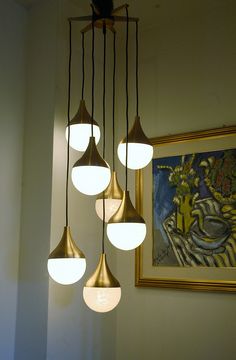 a chandelier with five lights hanging from it's sides in a dining room