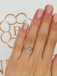 a woman's hand with a ring on it and a diamond in the middle