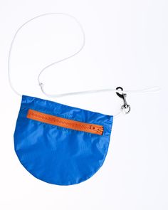 a blue purse with an orange zipper on the front and white strap hanging from it