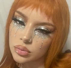 a woman with red hair and silver glitter makeup looks at the camera while posing for a photo