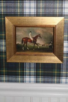 a painting of a man riding a horse on a tartan covered table with blue and green plaid