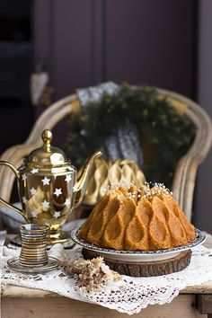 a bundt cake sitting on top of a table next to a tea pot