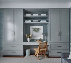 a room that has some gray cabinets and drawers in it, along with a chair