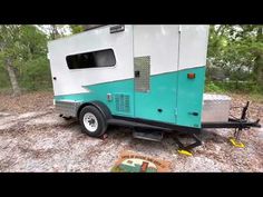 the trailer is parked in the middle of the woods with no one around it or on the ground