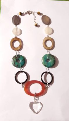 "Attractive natural choker necklace that can worn daily. In great vintage condition. Center of necklace is large round open center Carnelian gemstone Round open circle green turquoise beads. Brown Agate open oval bead. Also frosted  crystal round bead. And brown Agate in oval shape. Three small Tiger Eye beads at the end of necklace. The gemstones are link with sterling silver wire. Measures 10\" around the necklace. Lobster clasp is 9.25 Sterling Silver" Ocean Springs Ms, Ocean Springs, Heart Choker Necklace, Brown Agate, Heart Choker, Tiger Eye Beads, Crystal Chain, Cowrie Shell, Stone Gold