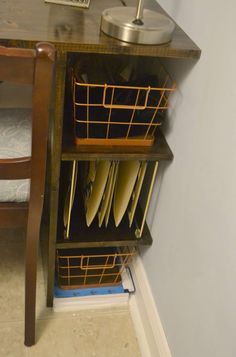 a wooden table with plates and cups on it next to a shelf filled with dishes