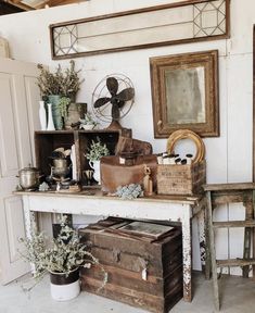 an old table with many items on it in a room filled with furniture and decor