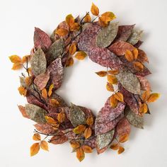 a wreath made out of leaves on a white surface