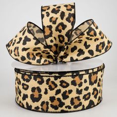 a leopard print ribbon with black and brown spots on the side, tied to a white box