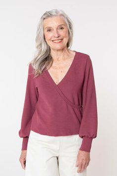 an older woman with grey hair wearing a burgundy top