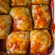 an enchilada casserole in a baking dish with sauce on top