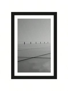 black and white photograph of four people walking on the beach with one person in the distance