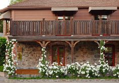 an old building with white flowers growing on the outside and balcony railings above it