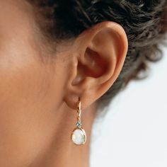 Our elegant gold drop earrings feature organically-shaped rainbow moonstones with brilliant blue cubic zirconia accents.

Thanks to their ethereal blue and white tones, these moonstone dangle earrings are truly one-of-a-kind!

The rainbow moonstones measure at 10mm x 8mm and cubic zirconia stone measure at 2.5mm.

Inner earring diameter measures at 10.5mm. Ethereal Blue, Moonstone Earrings, Blue Gems, Sustainable Jewelry, Traditional Jewelry, Gold Drop Earrings, Recycled Sterling Silver, Moon Stone, High Quality Jewelry