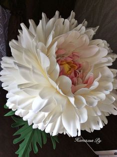 a large white flower sitting on top of a wooden table