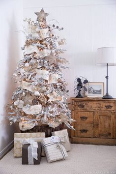 a white christmas tree with presents under it