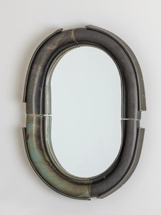 an oval mirror hanging on the wall