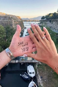 two people holding their hands up to each other with the words she said yes written on them