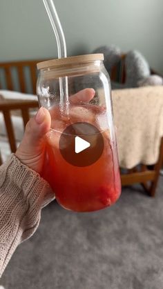 a person holding up a jar with liquid in it