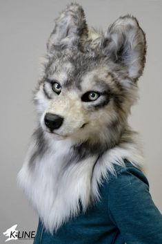 a stuffed wolf is wearing a sweater and looking at the camera with an angry look on his face