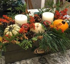 a wooden box filled with lots of different types of flowers and candles on top of a table