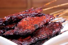 barbecued meat on a plate with chopsticks