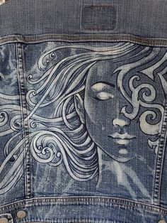 the back of a jean jacket with an image of a woman's face on it