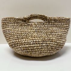 a large woven basket sitting on top of a white table