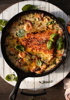 a skillet filled with food on top of a wooden table