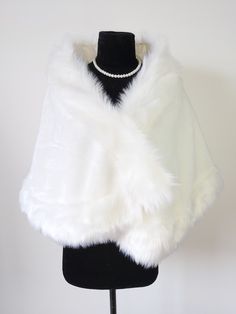 a white fur cape on a mannequin stand