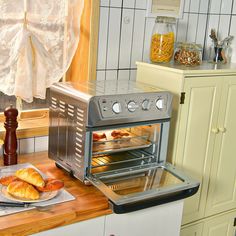 there is a silver toaster oven and some food on the counter in this kitchen