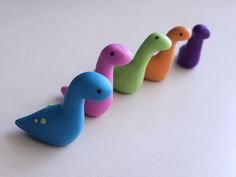 five different colored toy birds lined up in a row