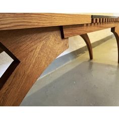 a close up view of a wooden table with curved legs and wood grained edges