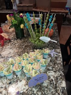 there are many cupcakes on the table with candy sticks and flowers in them