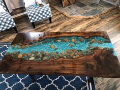 a coffee table with blue and brown paint on it in a living room area next to a fire place