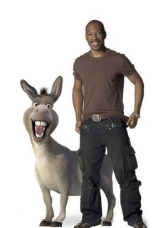 a man standing next to a donkey with it's mouth open