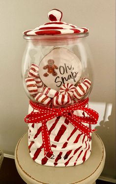 a glass jar with candy in it sitting on top of a table