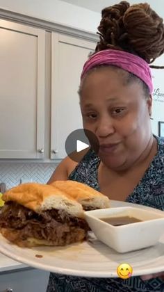 a woman holding a plate with a sandwich on it