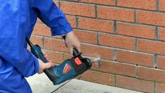 a man is using a power drill to fix a brick wall with a cordless screwdriver