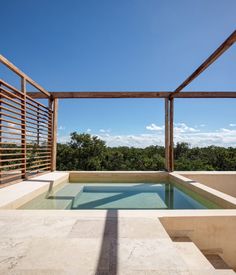 an outdoor swimming pool in the middle of a patio with wooden slats on it