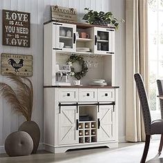 a dining room table and chairs in front of a white hutch