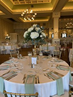 the tables are set with place settings and centerpieces for an elegant wedding reception