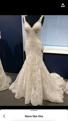 a wedding dress on display in front of a window