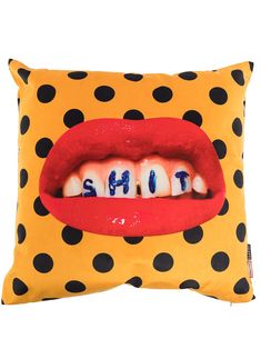 a yellow pillow with black and white polka dots on it that has the word shut in front of a red lip