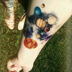 a person's arm with tattoos on it that have planets and stars painted on them