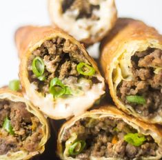 several burritos stacked on top of each other with meat and green onions in them