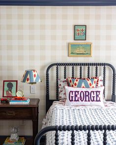 a bedroom with a bed, nightstand and pictures on the wall