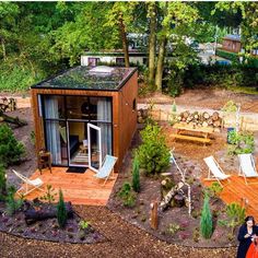 a woman standing in front of a tiny house