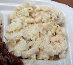 a white plate topped with meat and macaroni salad