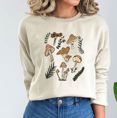 These mushroom sweatshirts are perfect all year round! They are great for layering. These sweatshirts are 50% pre-shrunk cotton, 50% polyester.  Wash on cold, dry inside out. Do not iron over design.  Processing time is 7-10 business days plus an additional 2-5 business days for standard shipping. Please message me if you need it sooner and I can see if I have the inventory on hand already. Relaxed Fit Fall Tops With Mushroom Print, Spring Cotton Tops With Mushroom Print, Relaxed Fit Top With Mushroom Print For Fall, Spring Cotton Top With Mushroom Print, Relaxed Fit Mushroom Print Top For Fall, Cotton Fall Sweatshirt With Mushroom Print, Cotton Sweatshirt With Mushroom Print, Cotton Sweatshirt With Mushroom Print For Fall, Winter Cotton Tops With Mushroom Print